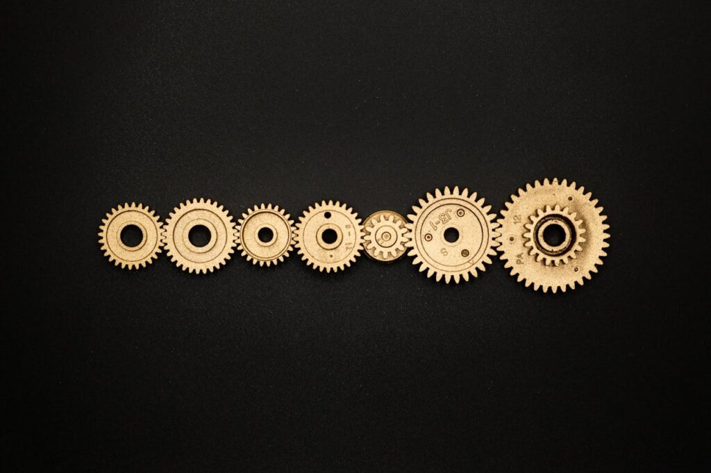 An artistic arrangement of golden gears on a dark backdrop, symbolizing mechanics and cooperation.