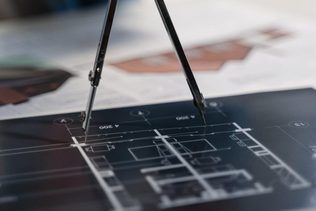 pexels photo 6615086 A compass on architectural blueprints, showcasing planning and measurement details.